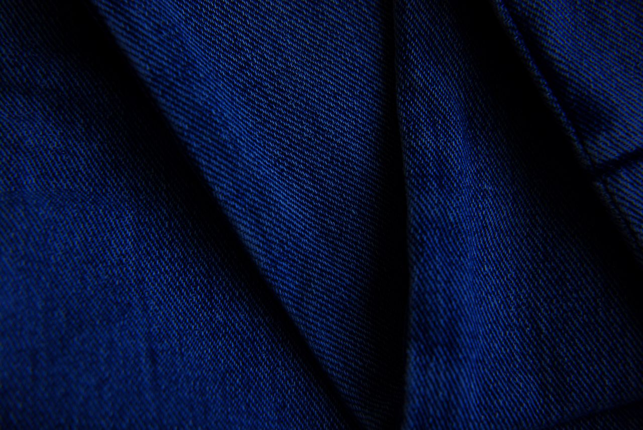 detailed close up of blue denim fabric showcasing texture and pattern