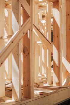 Close-up of wooden beams and framework in construction site, bathed in sunlight.
