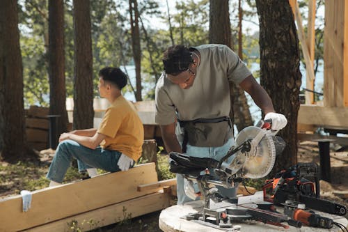 Man Cutting Planks of Wood