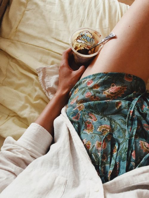 Free Enjoying a relaxed morning in bed with a cup of yogurt, wrapped in cozy attire. Stock Photo