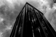 一张黑白照片捕捉到了南非桑顿一座高耸的摩天大楼，上方笼罩着不祥的云层