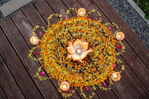 Beautiful Flower Petals Surrounded by Lighted Candles on a Wooden Surface