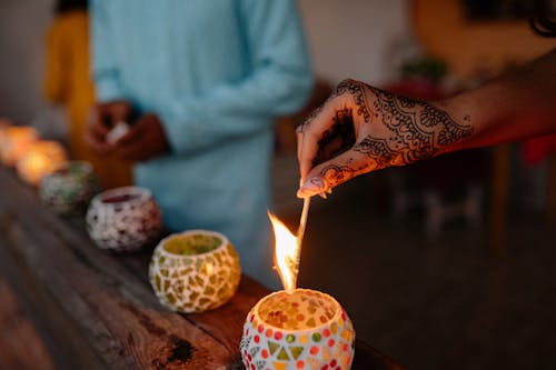 Free Person Holding Lighted Candle on Brown Wooden Table Stock Photo