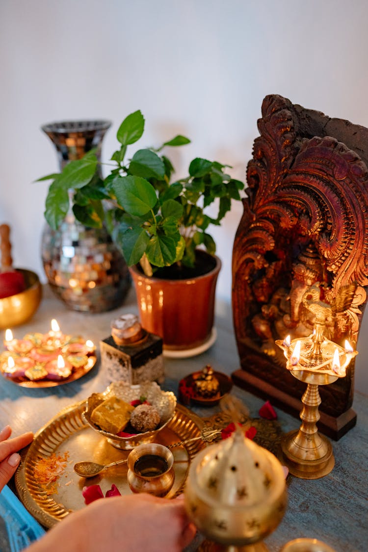 A Person Putting Golden Plate With Food On The Altar
