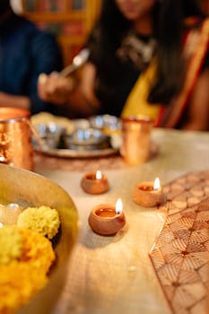 A warm and festive scene depicting lit diyas on a table, with a traditional Diwali meal being enjoyed.
