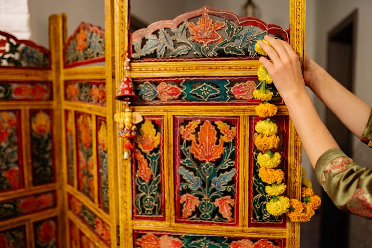 Person Hanging A Garland On A Wooden Divider