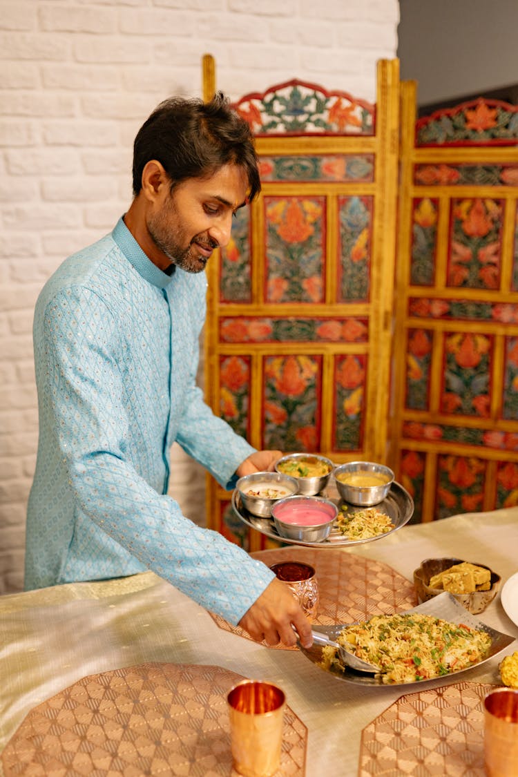 Man In Blue Kurta Scooping Food On The Table