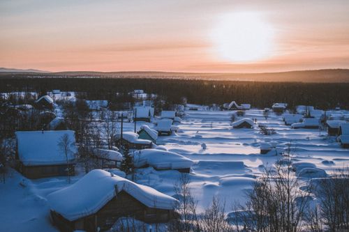 Free A picturesque village blanketed in snow during sunrise, showcasing serene winter beauty. Stock Photo