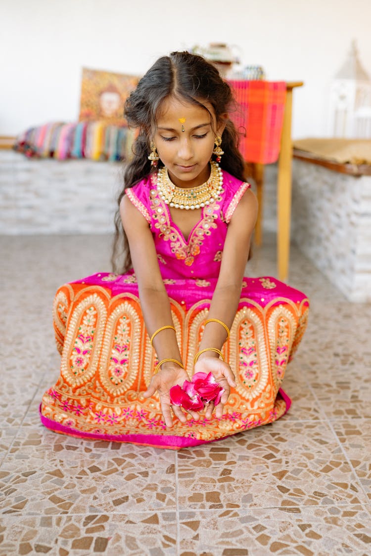 Teenage Girl Sitting And Holding Flowers In Her Pink Saree Dress