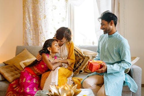 Free A Happy Family Sitting on the Couch while Wearing Their Traditional Clothes Stock Photo