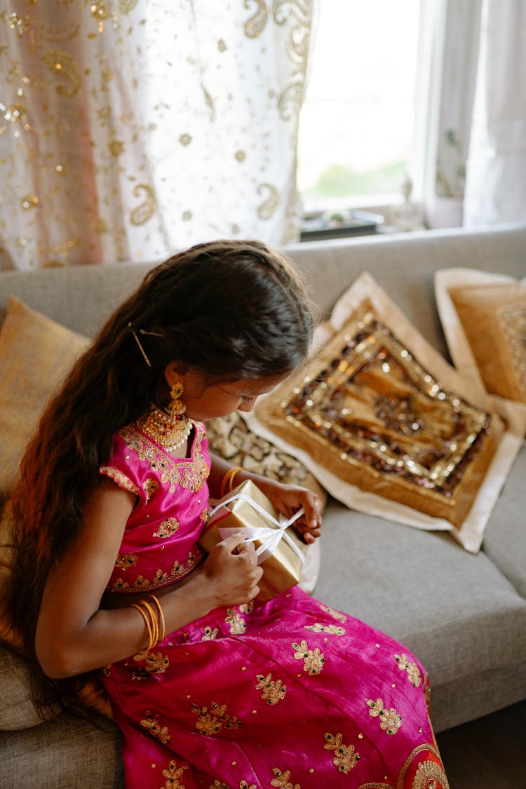 A Young Girl Opening A Gift 