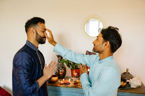 Man Putting Dot on Other Man Forehead