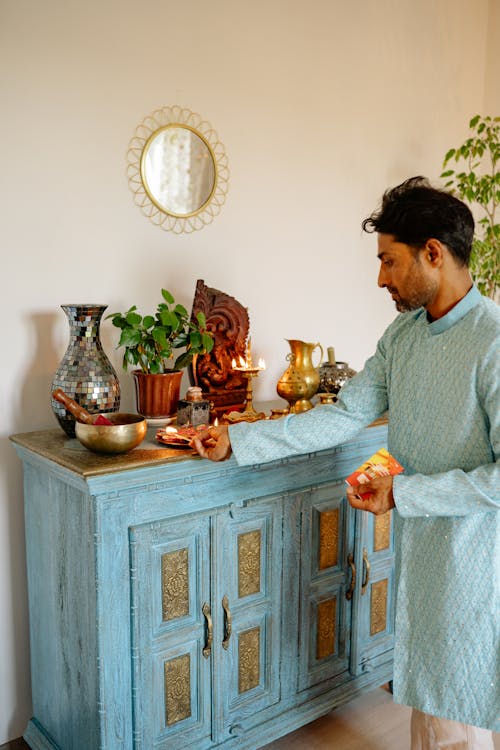 Man Burning Candle on Home Altar