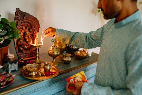 Free A man in traditional attire lighting a Diwali lamp, showcasing Indian culture and traditions. Stock Photo
