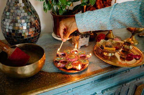 Man Lighting Decorative Candles on a Wooden Cupboard