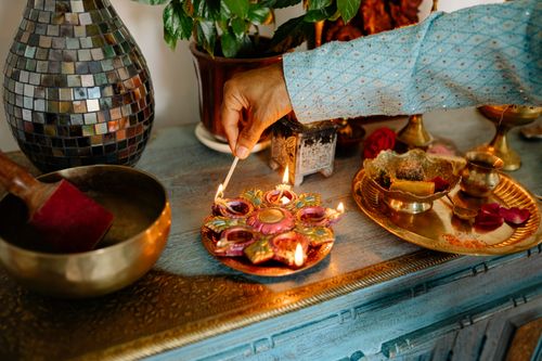 Free Hand lighting a decorative diya for an Indian festival celebration. Stock Photo