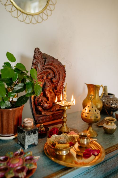 Free A serene Hindu altar setup featuring candles, brassware, and a Ganesh carving, symbolizing spirituality and tradition. Stock Photo