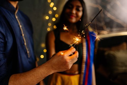 Free A close-up of a person holding sparklers, celebrating Diwali indoors. Stock Photo