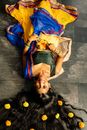 Woman in Blue and Yellow Dress Lying on Gray Concrete Floor