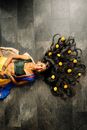 Woman in Blue and Yellow Dress Leaning on Wall