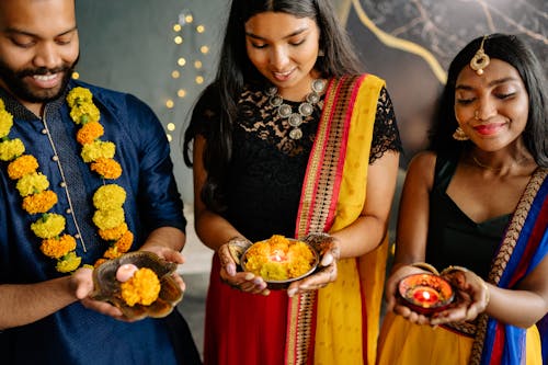 People in their Traditional Dress carrying Brass Plates with Flowers 