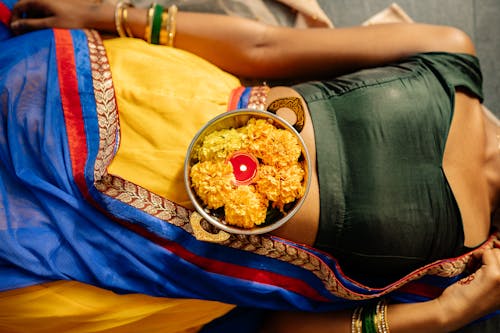 Bowl of Marigold Flowers on Top of a Person 