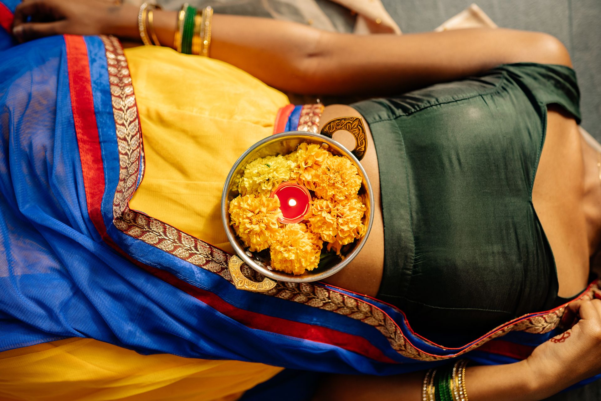Bowl of Marigold Flowers on Top of a Person