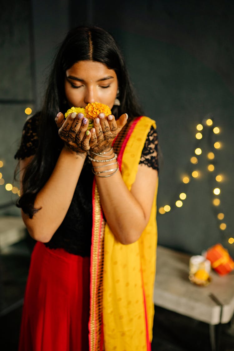 A Woman Smelling A Flower