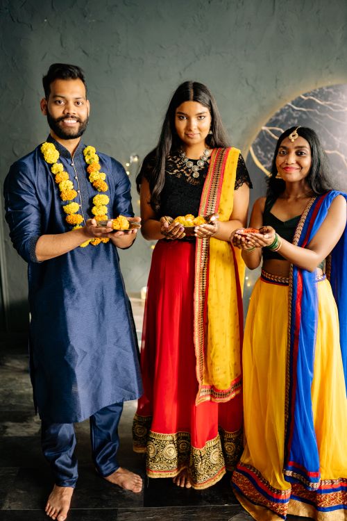 Free Group of South Asian adults in traditional clothing celebrating Diwali indoors. Stock Photo
