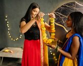 Woman in Red and Gold Sari Dress Holding Gold Crown