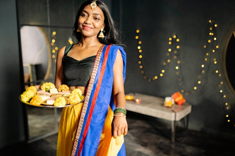 Woman In Traditional Wear Holding A Food Platter