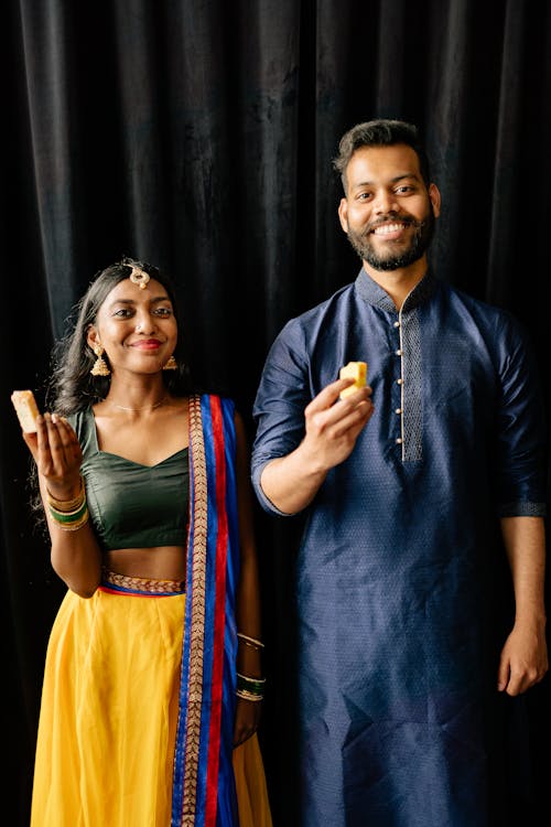 Smiling Couple Holding Cakes