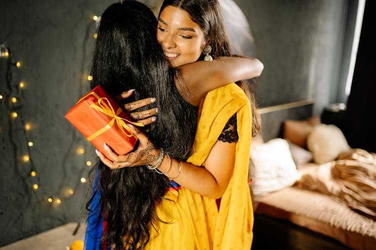 Women Wearing Sari Hugging Each Other 