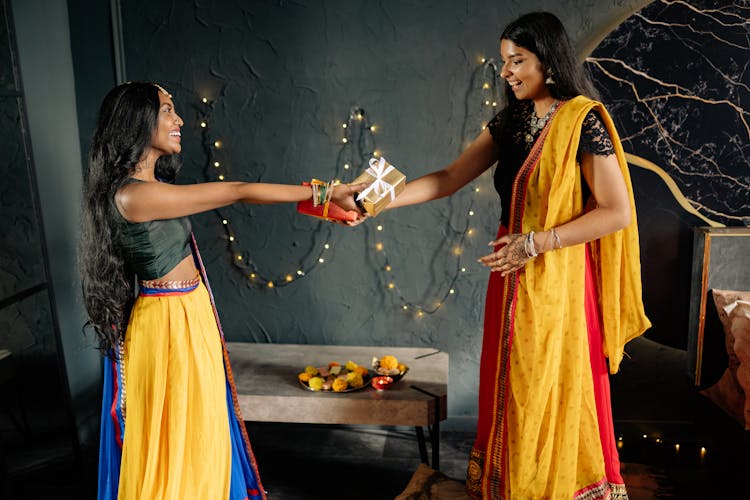 Women In Traditional Wear Exchanging Gifts