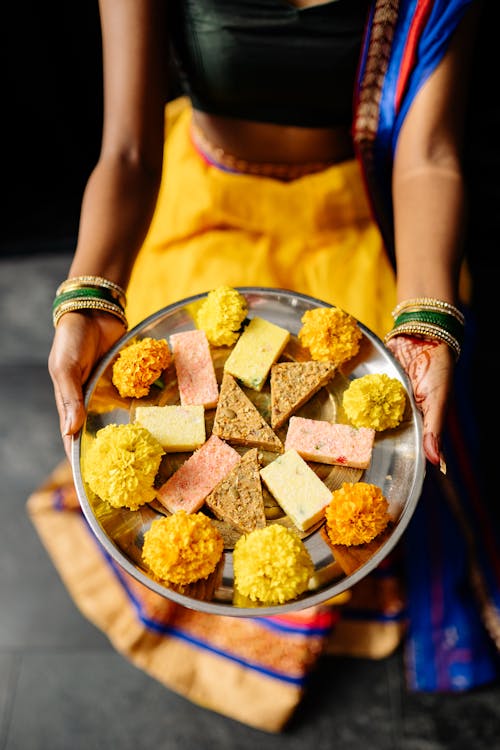 Free Person Holding Stainless Steel Plate of Traditional Desserts  Stock Photo