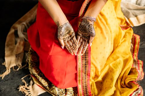Free Close-up of henna-decorated hands in traditional Indian outfit, symbolizing cultural celebration. Stock Photo