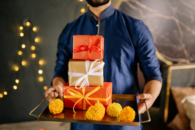 Man In Blue Long Sleeves Holding Gifts