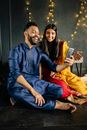 Man in Blue Dress Shirt Sitting Beside Woman in Yellow Dress
