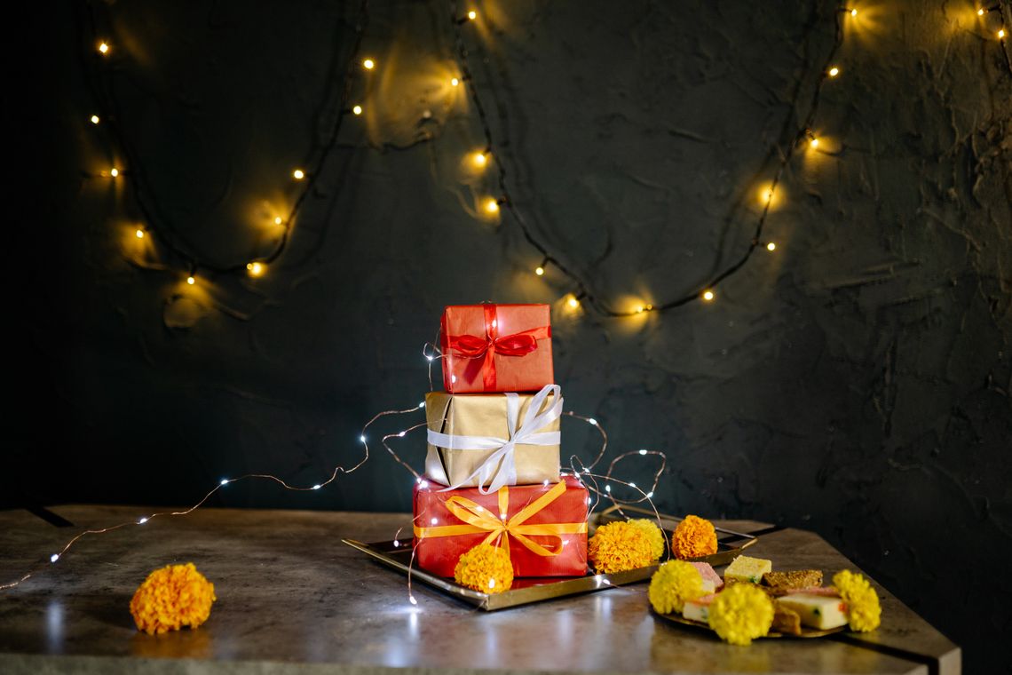Festive wrapped gift boxes arranged with lights and floral celebration decor