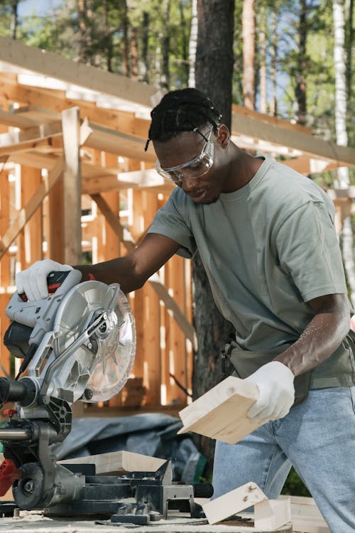 A Man Cutting Wood Plank