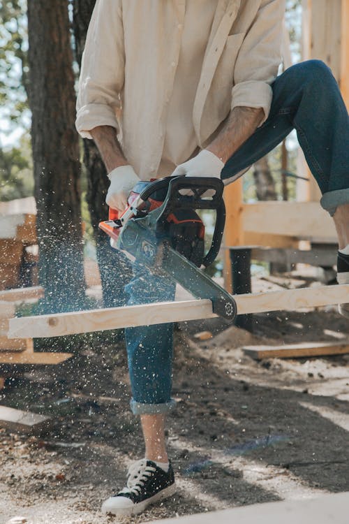 Man Cutting a Wooden Plank