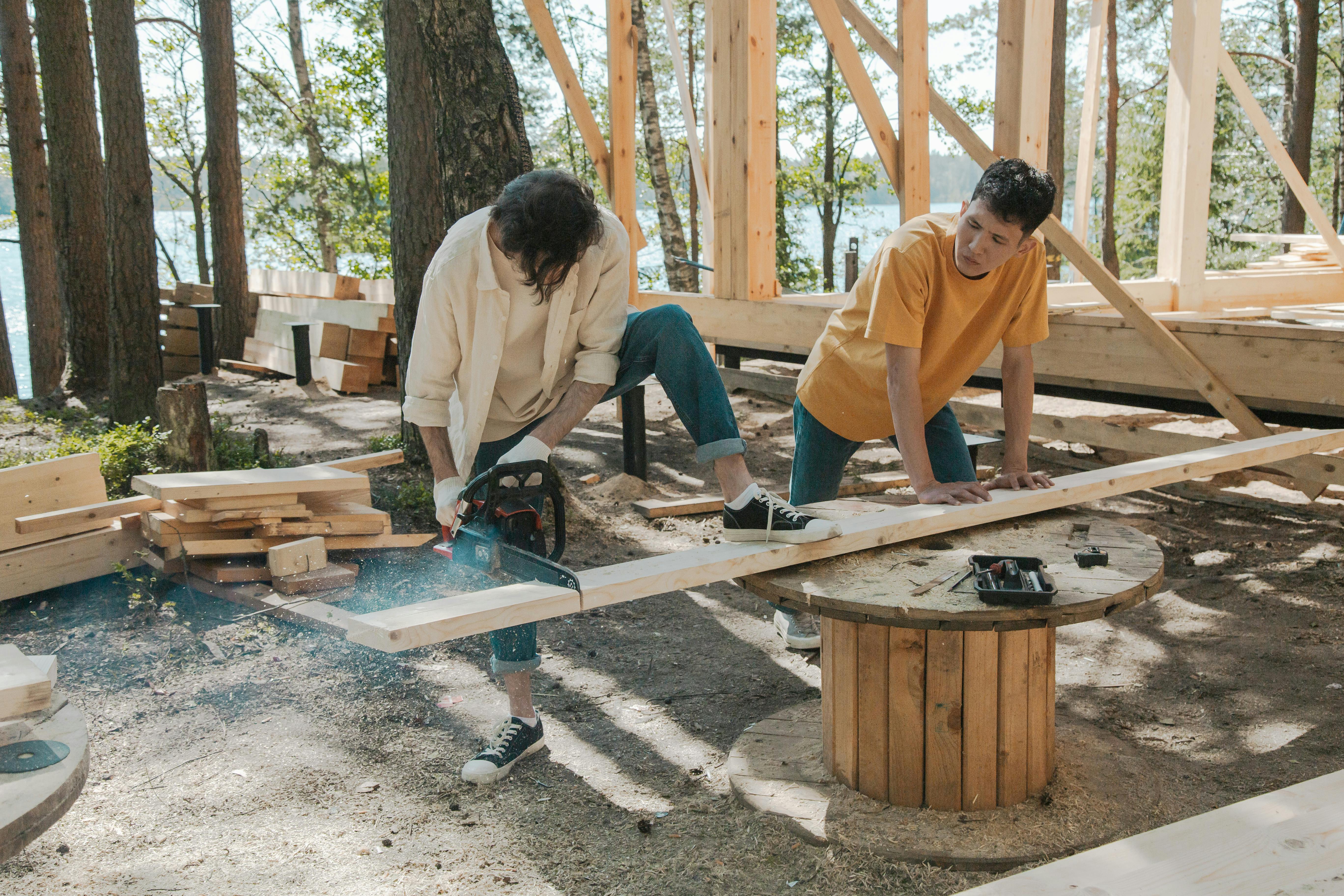 a man cutting wood plank using chainsaw