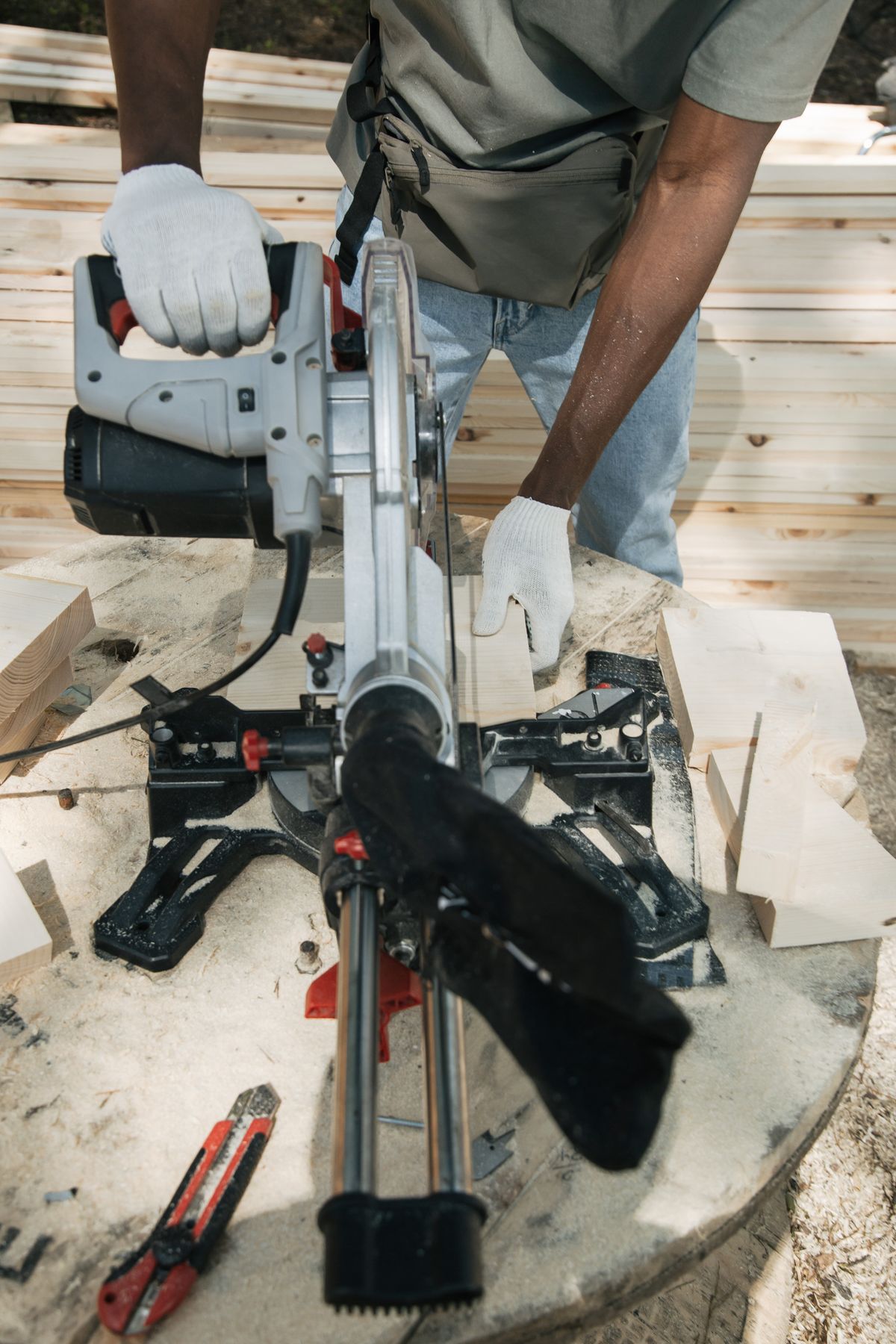 Builder cutting framing lumber with a circular saw on site