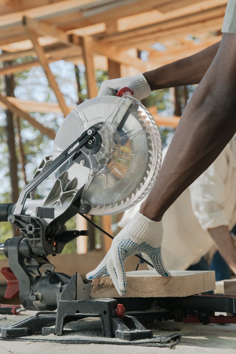 A Person Cutting Wood Using Circular Saw