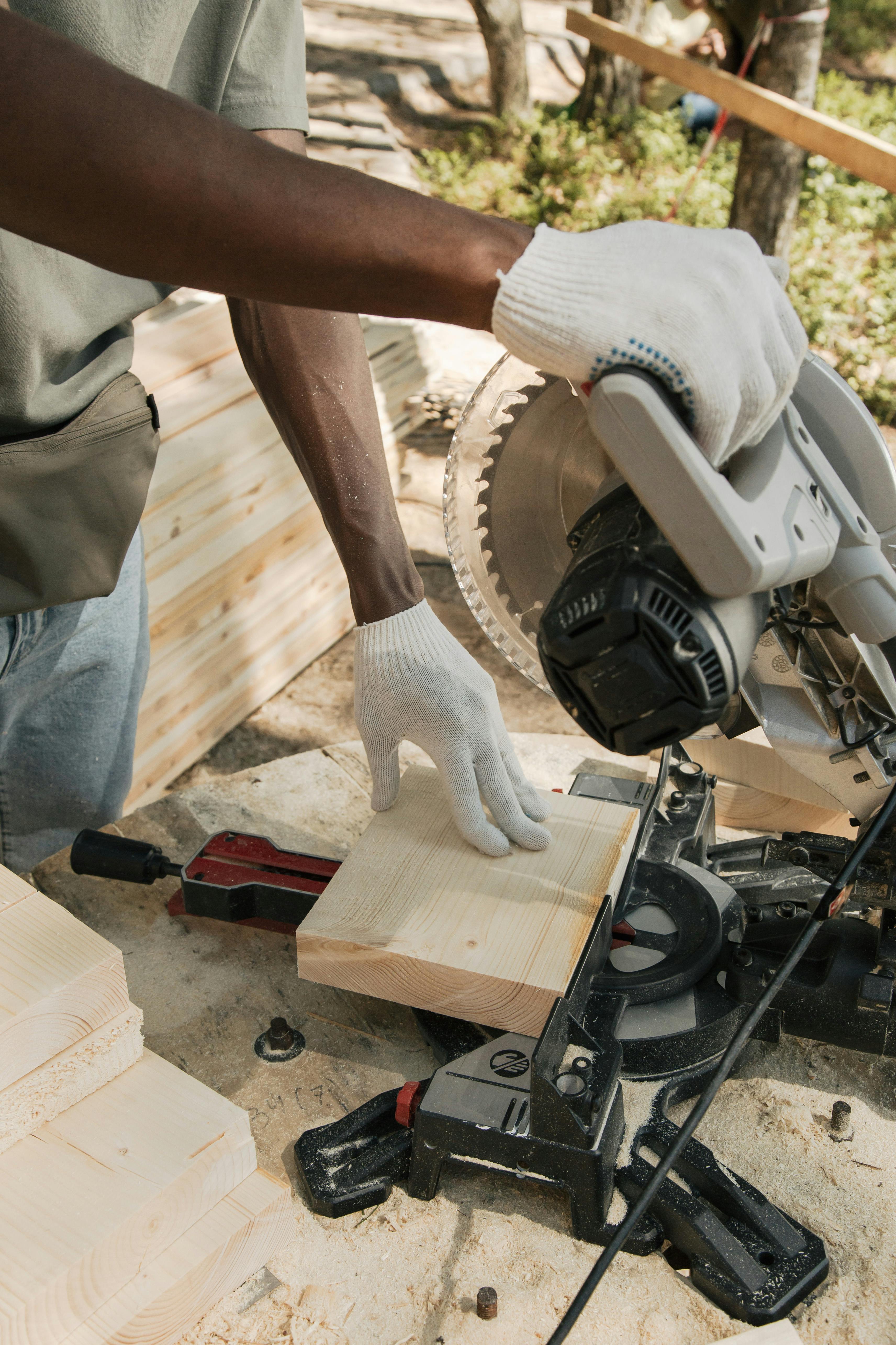 a person cutting wood using circular saw