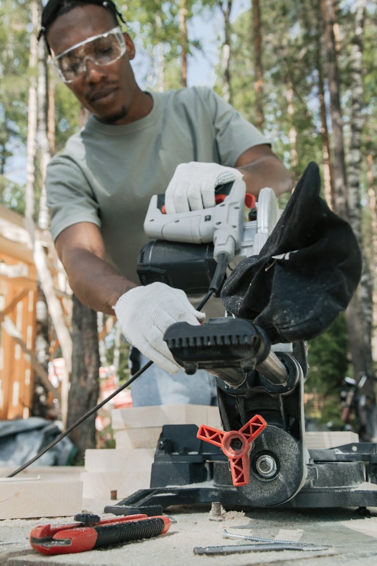 Man Holding Saw Machine