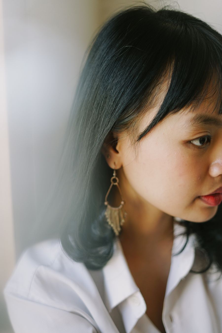 Woman in a white shirt wearing contemporary dangling earrings