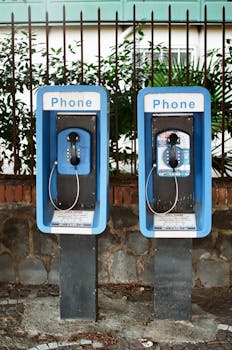 Two vintage payphones against a stone wall in Pompei, Italy.