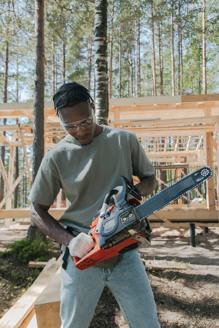 A Man Holding A Chainsaw