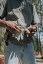 Person in Gray Shirt and Blue Denim Jeans Holding White and Black Textile